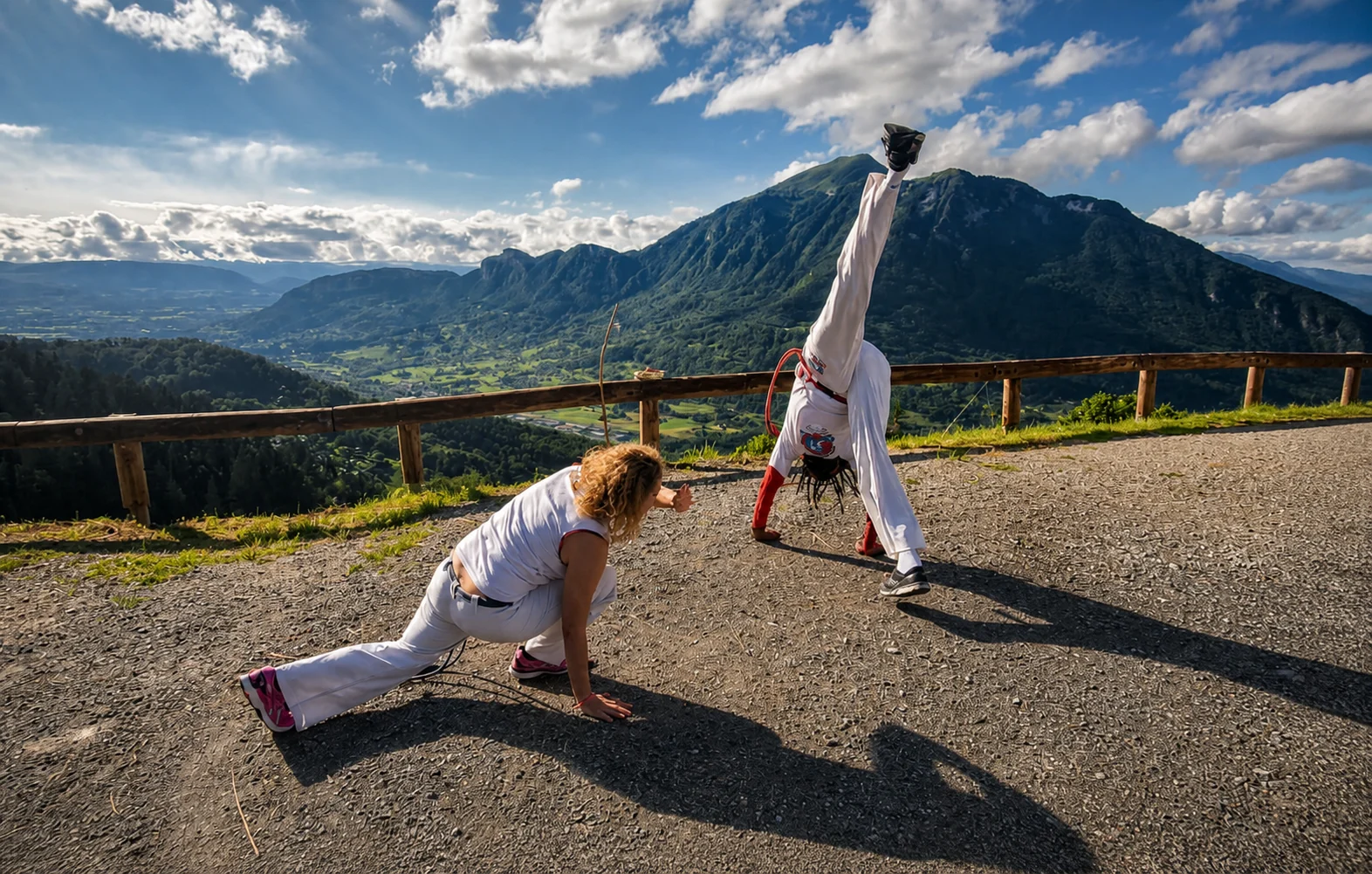 Mestre Cobra Preta et Fabiana pratiquant la capoeira face aux Alpes